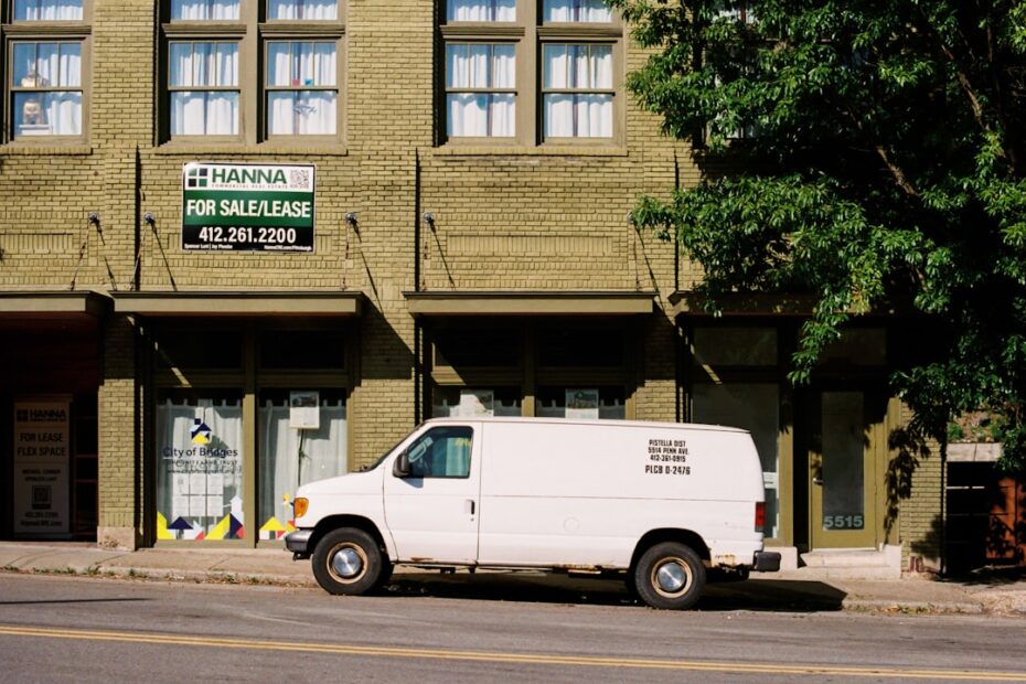 Uma Van Branca Estacionada Em Frente a Um Predio Alto e3X_0xDUE8E