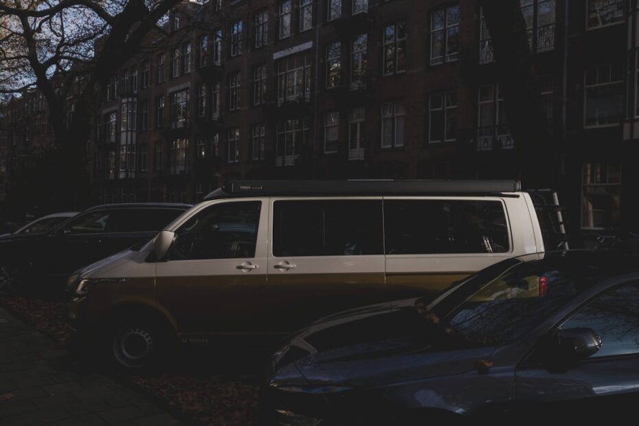 Uma Van Bicolor Estacionada Ao Lado Dos Carros Na Rua _Bq0pKRWis8