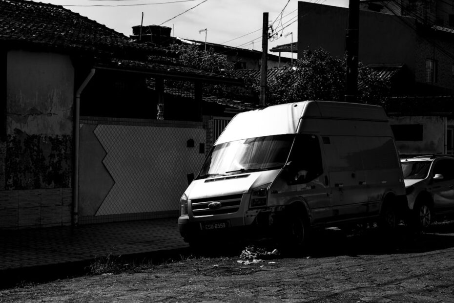 Van Branca Estacionada Numa Rua Ao Lado De Predios XcLEEXQ522k