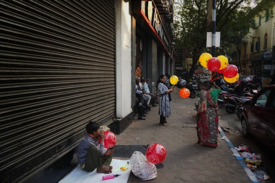 Um Grupo De Pessoas Sentadas Ao Lado De Uma Rua Fistlj9D1sE