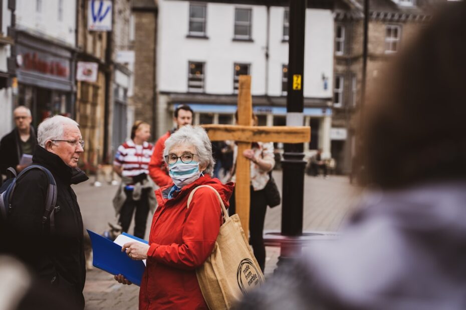 Uma Mulher Usando Uma Mascara Facial Em Pe Na Frente De Uma Cruz 9frVT3XZKbE