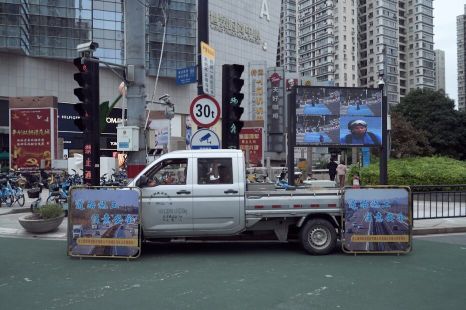 Um Caminhao Dirigindo Por Uma Rua Ao Lado De Predios Altos o9cHdO0I9 M