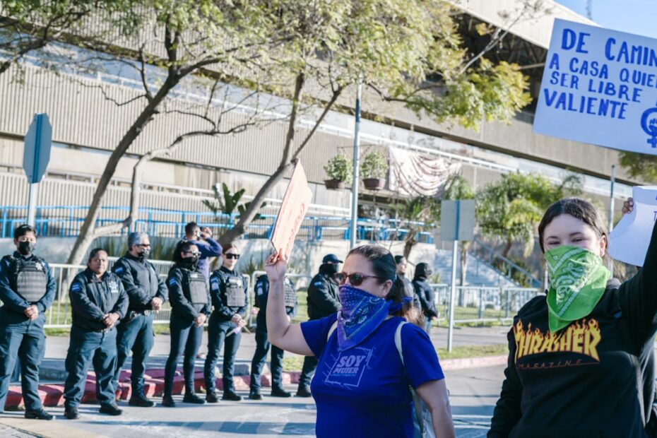 Uma Mulher Segurando Um Sinal Na Frente De Um Grupo De Pessoas ucZvN0jaFMY
