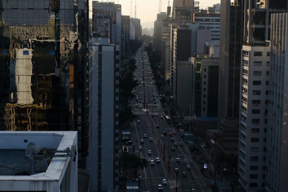 Aerial urban view of Avenida Paulista, São Paulo, with reflections on modern buildings during twilight.