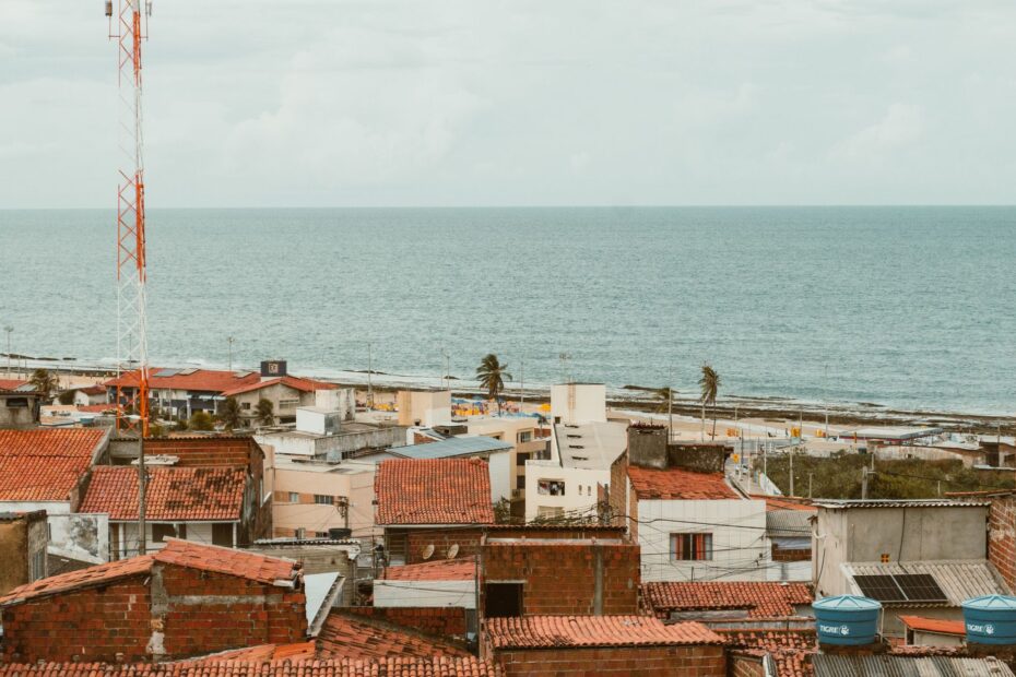 Aerial view of Natal, RN, Brasil, showcasing red rooftops and Atlantic Ocean coastline.