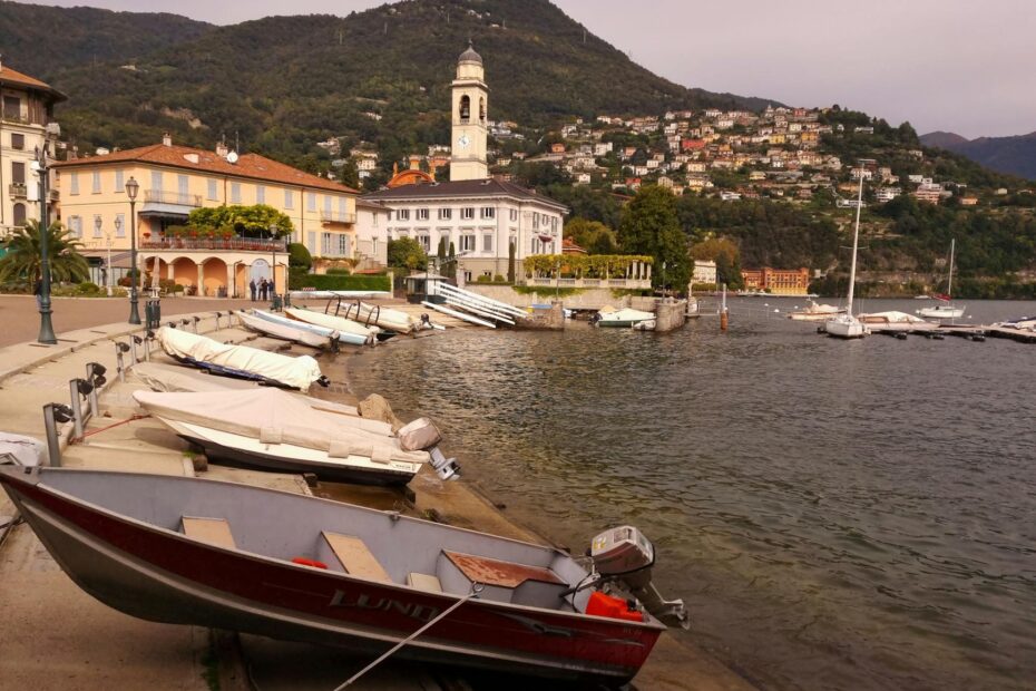 Peaceful harbor scene at Lake Como with boats and scenic hillsides.