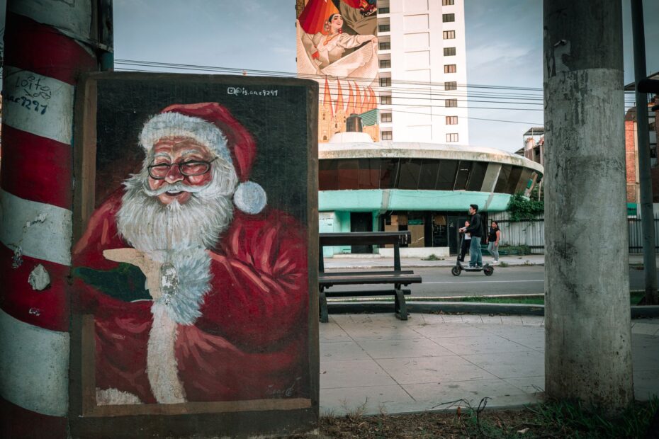 Street art of Santa Claus on a colorful mural in Trujillo, Peru, with urban backdrop.
