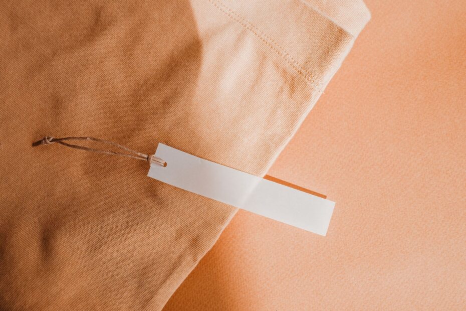 Close-up of a beige fabric with a blank white tag, perfect for branding or mockup.