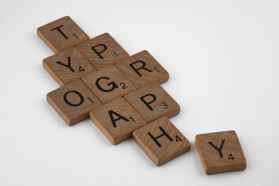Close-up of Scrabble tiles spelling 'typography' on a white surface.