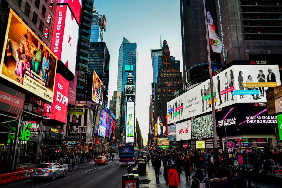 Dynamic cityscape of Times Square, New York, bustling with lights and activity at dusk.