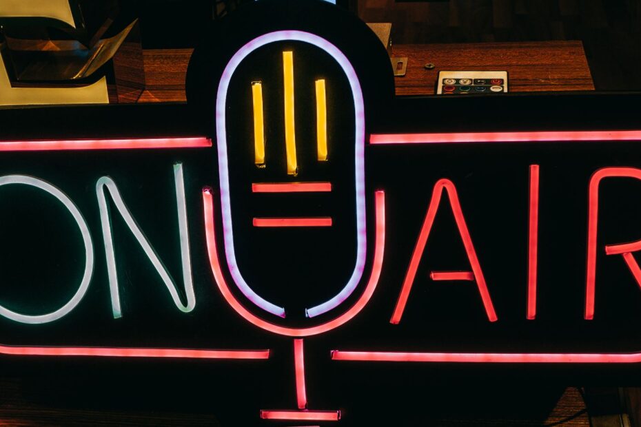 Bright neon 'On Air' sign glowing in a dark studio, perfect for broadcasting themes.