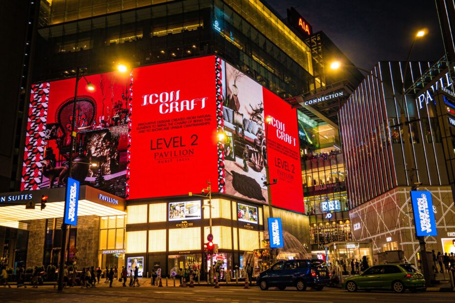 Vibrant nighttime view of Pavilion Kuala Lumpur with bright digital displays and pedestrians.