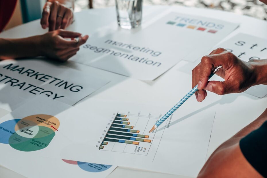 Team working on marketing strategy using data charts and papers in an office meeting.