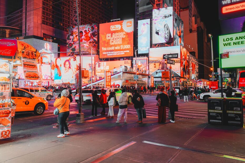 Bustling nighttime in Times Square, with bright advertisements and diverse crowd in New York City.