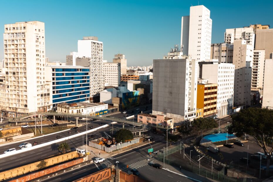 Aerial view of São Paulo's modern buildings and urban layout under a clear blue sky.