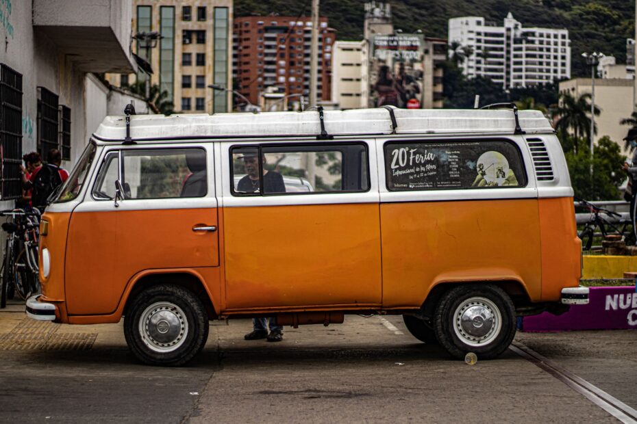 Retro Volkswagen van parked in a bustling city street, showcasing vintage charm.