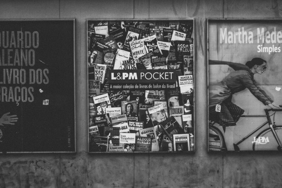 Black and white image of a wall with urban book posters and artistic design.