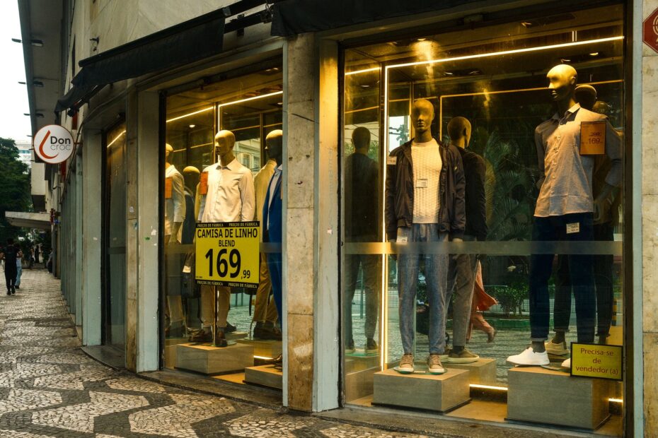 Stylish men's fashion display in a São Paulo storefront with mannequins showcasing modern apparel.