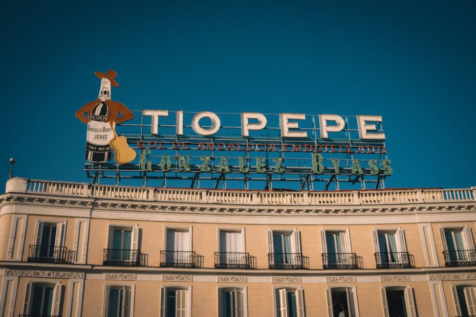 View of the famous Tio Pepe sign atop a classic building in central Madrid, Spain.