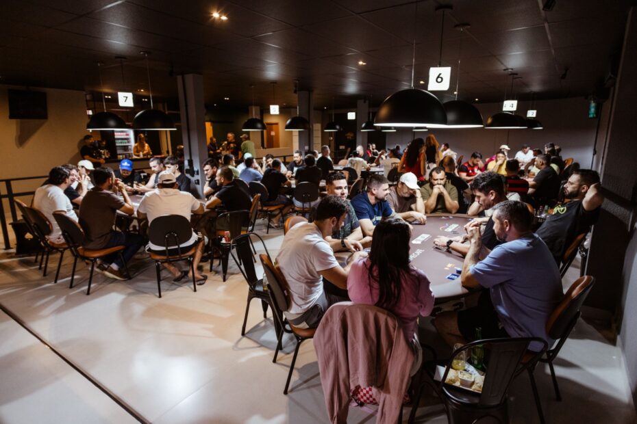 Intense poker game in a lively casino with multiple players. Experience the thrill and strategy of poker.