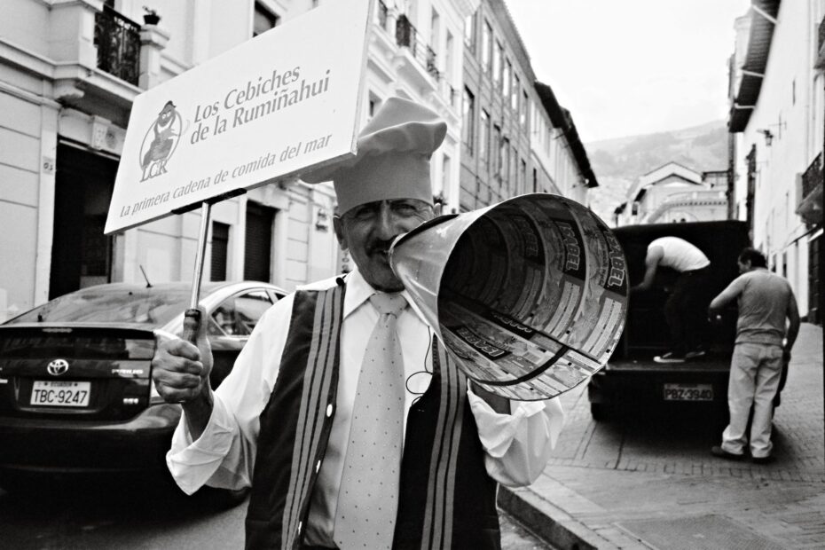 A chef promoting a seafood restaurant in Quito's historic center with a megaphone.