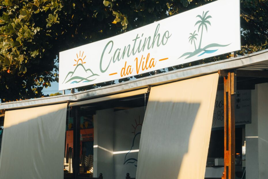 Charming outdoor café with sunlit sign 'Cantinho da Vila' in RN, Brazil.